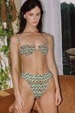 Bikini top with multicolored wavy petal print in turquoise, orange, and cream with thin shoulder straps.