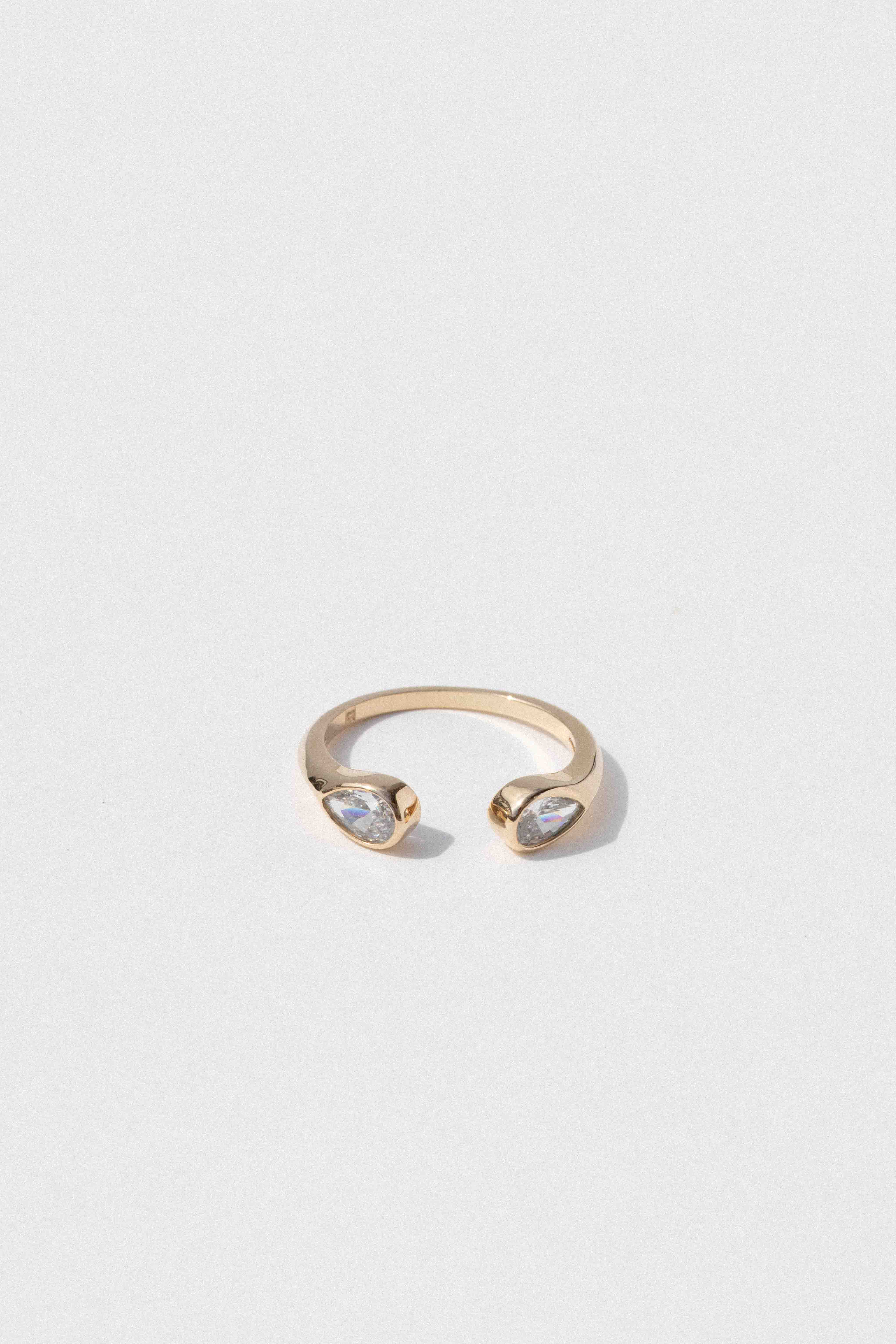 Gold-toned cuff ring with two teardrop-shaped clear cubic zirconia stones set on opposite ends.
