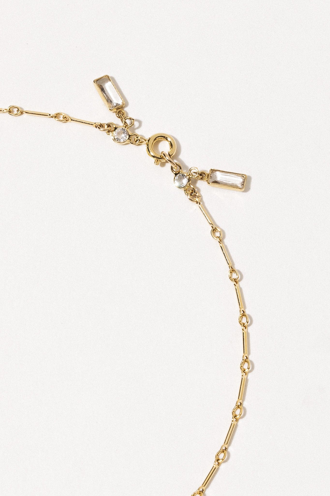 Gold-tone necklace with rectangular and round cubic zirconia crystals on an adjustable link chain.