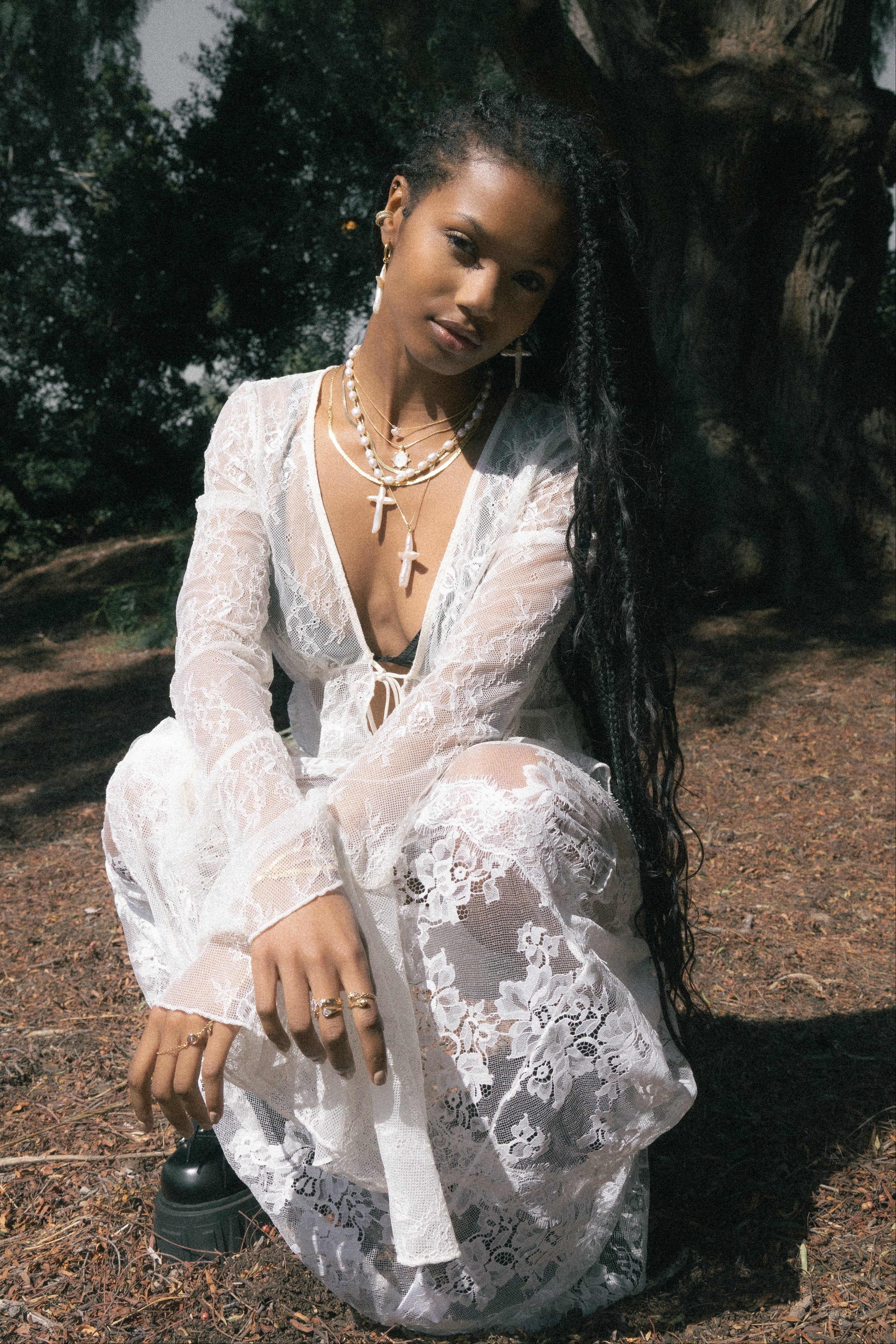 Layered pearl necklace with white cross pendants worn on woman's chest.