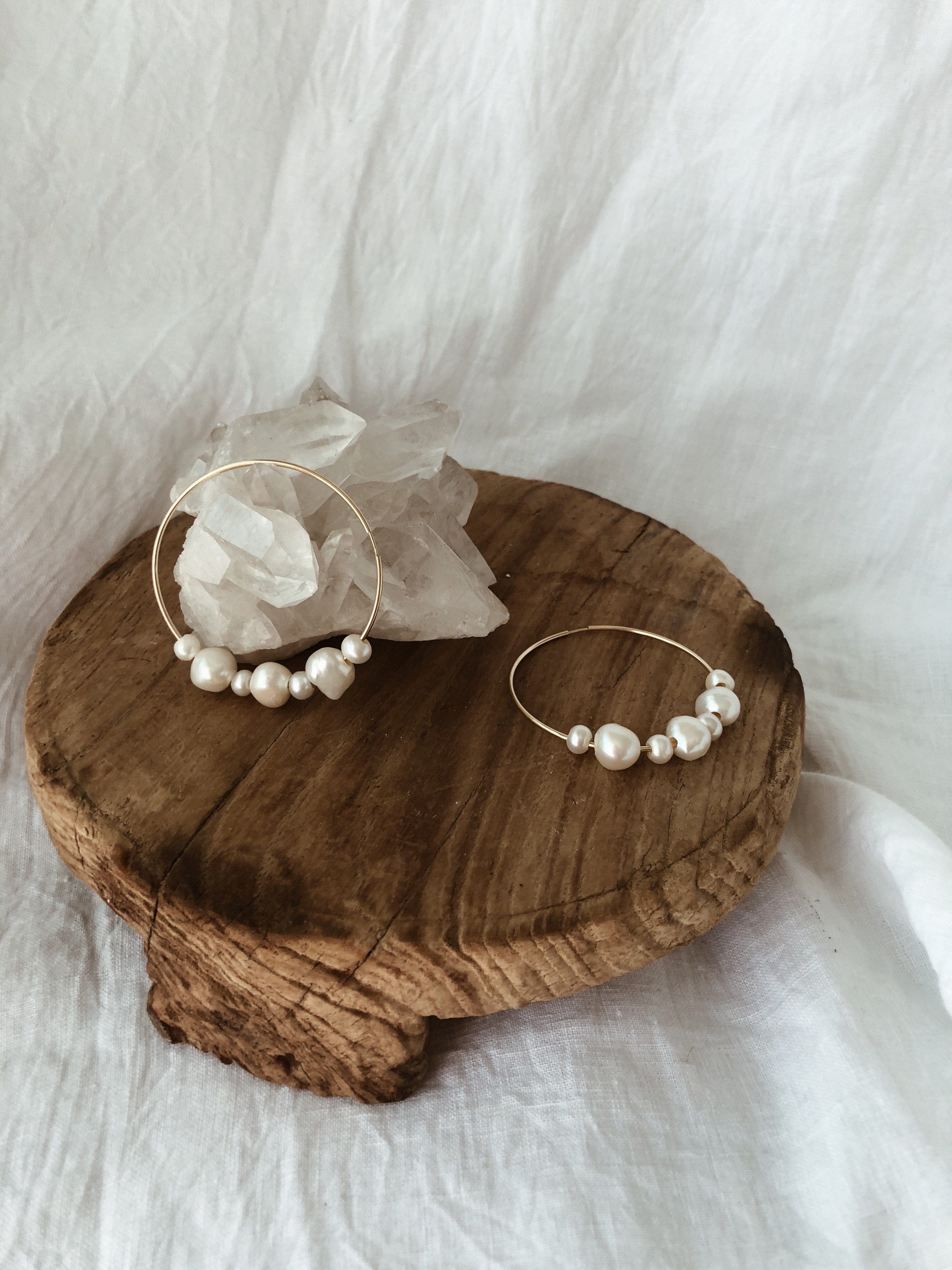 Pair of silver-tone hoop earrings with white pearl beads arranged in a semi-circle design.